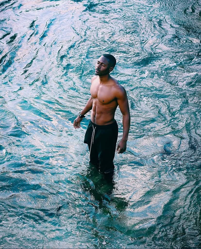 Sa'int Lucid standing in turquoise ocean water